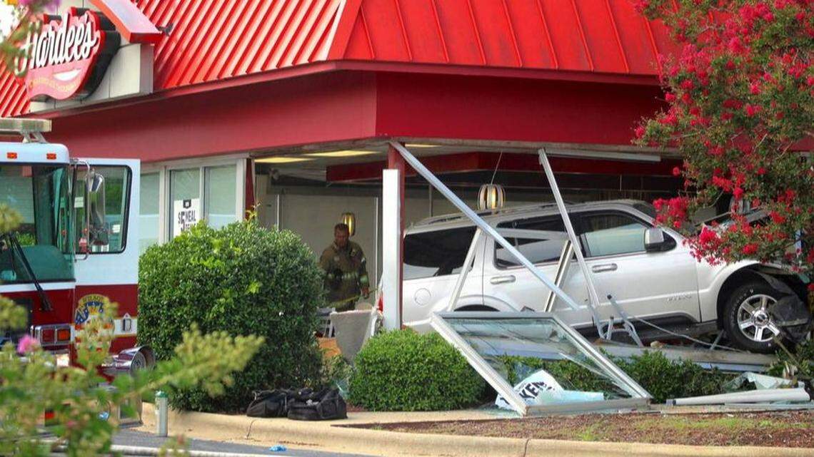 A Wilson, N.C., Fire/Rescue Services firefighter stands behind a sport utility vehicle that crashed into a Hardee’s restaurant on Sunday, Aug. 14, 2022, in Wilson, N.C.