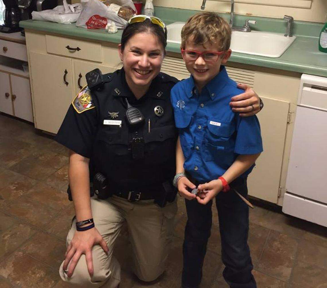 Bee County Sheriff's Deputy Lindsay Scotten poses with Wade Vielock's son, 6, who first noticed the snake slithering out of the family's toilet.