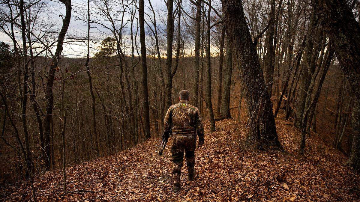 A hunter heads out into the woods to hunt for deer with a bow and arrow in Isonville, Kentucky, in 2017.