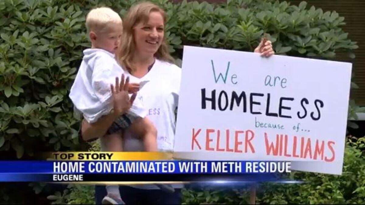 Denay Tubbs held her youngest son while the family picketed the Eugene, Oregon Keller Williams Realty offices on Thursday.
