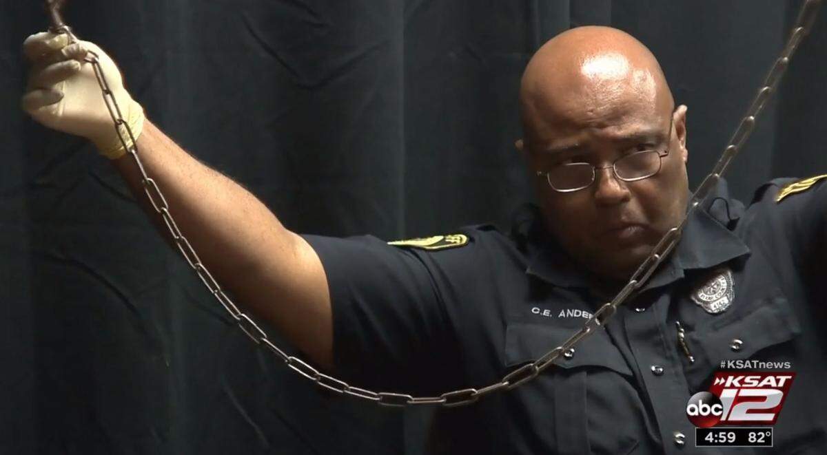 A witness for the prosecution holds up the chain used to confine a 4-year-old in the San Antonio backyard of Deandre Dorch and Porucha Phillips.