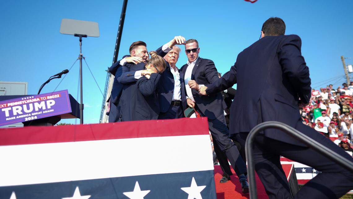 Former President Donald Trump is surrounded by Secret Service agents at a campaign rally in Butler, Pa, on Saturday, July, 13, 2024. Trump was escorted off the stage by Secret Service agents and into his motorcade just minutes into his rally in Butler, Pa., on Saturday, after a series of pops that sounded like gunshots rang out. (Doug Mills/The New York Times)
