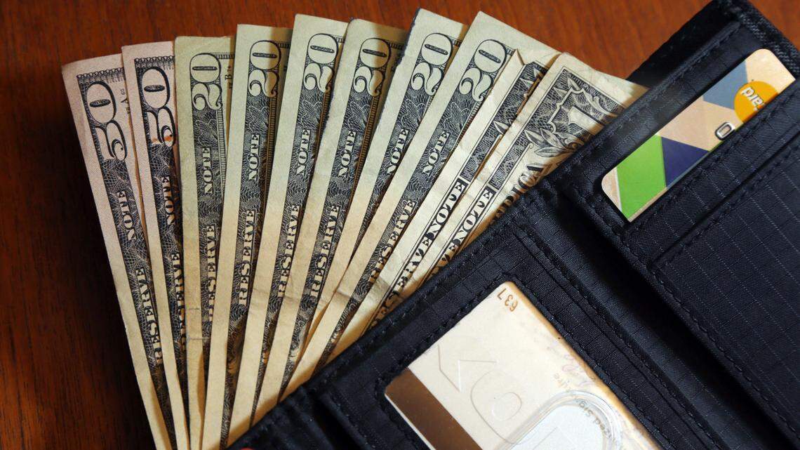In this June 15, 2018 photo, cash is fanned out from a wallet. After a New Orleans man was terminated from his job, he started demanding tens of thousands of dollars from his former employer, threatening to expose bogus illegal acts, according to Louisiana state troopers. He also demanded a settlement for his “pain and suffering.”