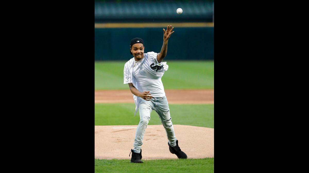 Chicago rapper G Herbo throws a ceremonial first pitch before a baseball game between the Chicago White Sox and the Washington Nationals Tuesday, June 11, 2019, in Chicago. He was charged in a fraud conspiracy on December 2, 2020. (AP Photo/Charles Rex Arbogast)