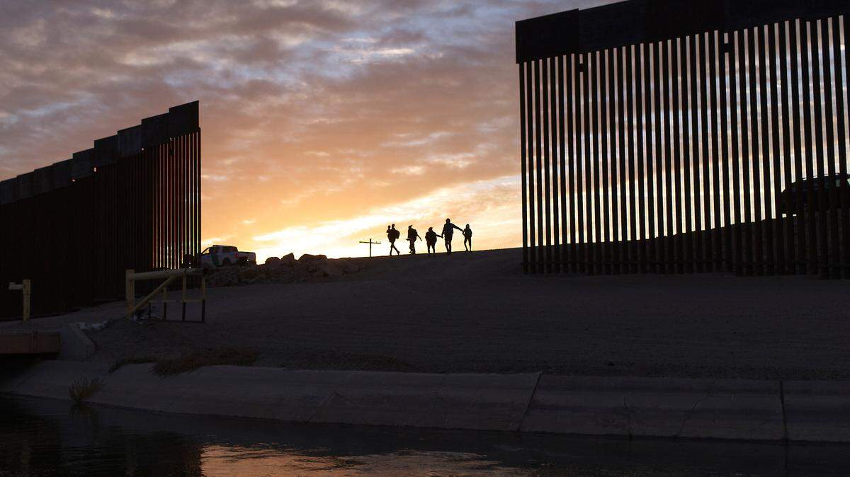 FILE - In this June 10, 2021, file photo, a pair of migrant families from Brazil pass through a gap in the border wall to reach the United States after crossing from Mexico to Yuma, Ariz., to seek asylum. (AP Photo/Eugene Garcia, File)
