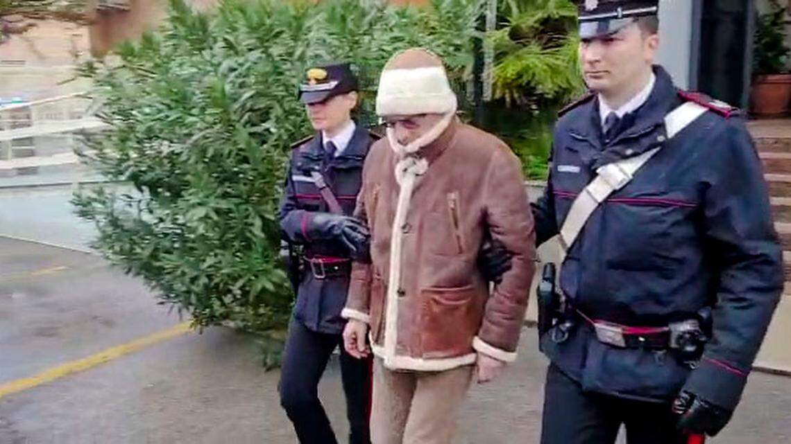 In this picture taken from a video released by Italian Carabinieri on Monday, Jan. 16, 2023, accused Mafia boss Matteo Messina Denaro, center, leaves an Italian Carabinieri barracks soon after his arrest at a private clinic in Palermo, Sicily, after 30 years on the run. (Carabinieri via AP)