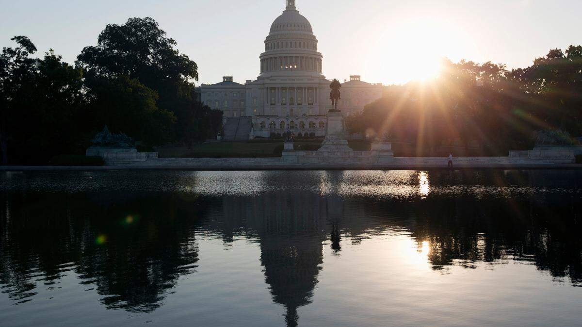 This Wednesday, Oct. 2, 2013 photo shows the Capitol building reflected in the Capitol Reflecting Pool at sunrise in Washington. A record-low share of Americans are optimistic about the prospects for future generations, according to a new Gallup poll. (AP Photo/Carolyn Kaster)
