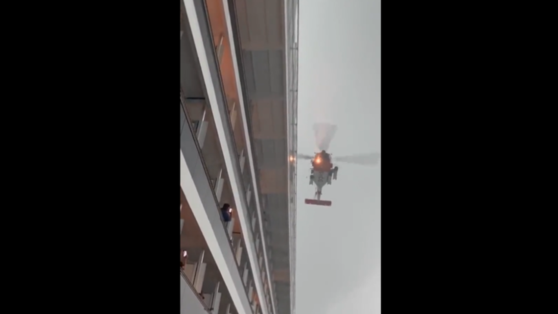 The helicopter fought against high winds as passengers watched it dip down to the water.