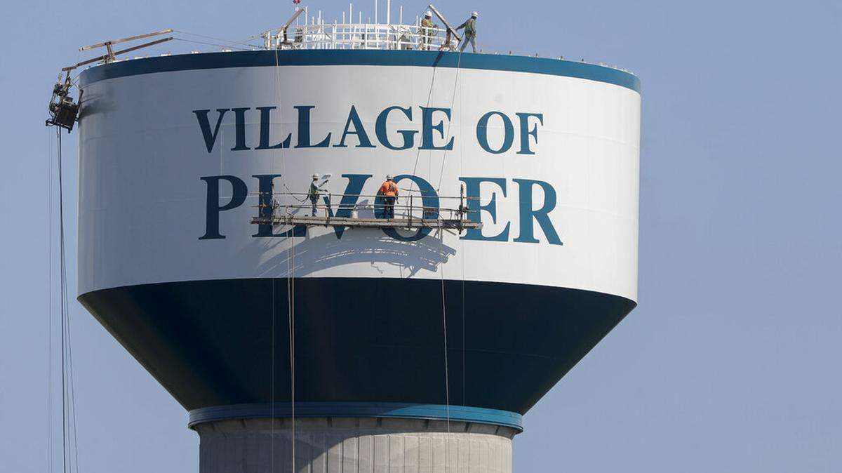 Paint crews work to fix a spelling error on the Plover water tower on Forest Avenue in Plover, Wis., on on Thursday, July 1, 2021. The Stevens Point Journal reports that crews repainting the tower on Thursday misspelled the village’s name as “Plvoer.” Village Administrator Dan Mahoney said the painters accidentally reversed the templates used to paint the letters before raising them up to the tower. (Tork Mason/The Post-Crescent via AP)