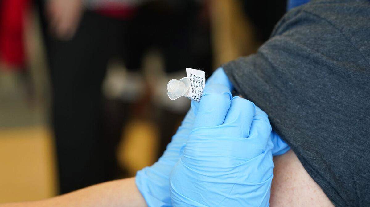 Brian Kennedy, right, a physical education teacher at Green Valley Elementary School, receives a COVID-19 vaccination from nurse Arielle Goode during a mass vaccination of 1,000 employees of Denver Public Schools including teachers, administrators, custodial workers and bus drivers at Denver Health Saturday, Feb. 13, 2021, in Denver. A CDC study of coronavirus transmission at Georgia elementary schools says preventing infection in teachers is an important part to stopping spread of COVID-19.