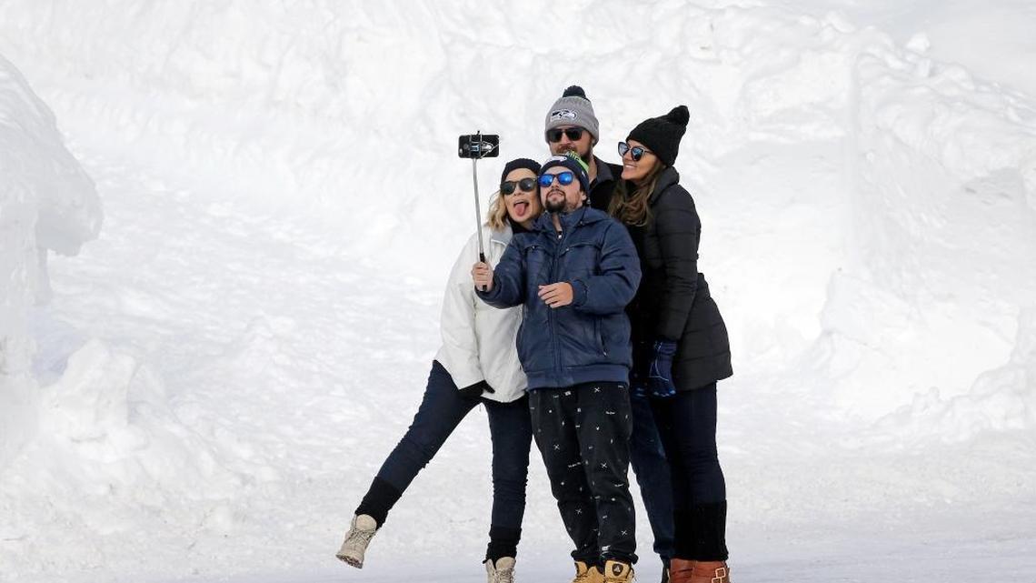 Visitors pose for a selfie on Dec. 16, 2016 in Mount Rainier National Park in Washington state. Mount Rainier and other national parks are weighing plans to expand cellular coverage in once remote areas. First responders support the plans, as do some park officials, who argue that better cell coverage will help attract a new generation of visitors. Critics fear it will lead to more noisy distractions in places designed to be an escape from the modern world.