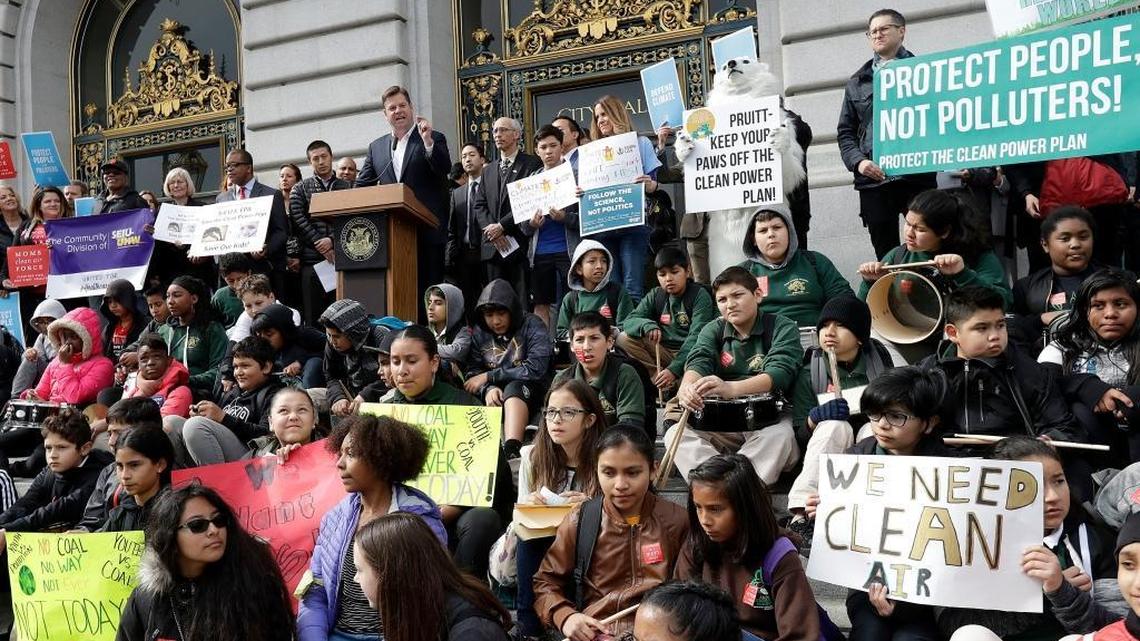 Acting San Francisco Mayor Mark Farrell, at podium, speaks at a rally for clean energy in San Francisco, Wednesday, Feb. 28, 2018. A U.S. District Court in San Francisco will be the setting for a first-ever hearing on the science of climate change, scheduled for March 21 by William Alsup, a federal judge.
