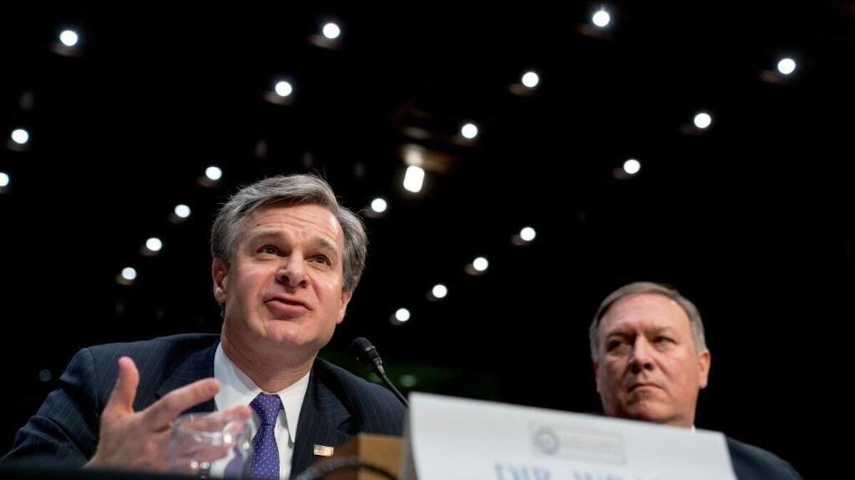 FBI Director Christopher Wray, accompanied by CIA Director Mike Pompeo, right, speaks at a Senate Select Committee on Intelligence hearing on worldwide threats, Tuesday, Feb. 13, 2018, in Washington.