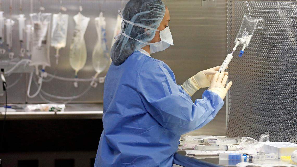 In this Friday, June 1, 2018, photo, a pharmacy technician prepares syringes in the sterile medicines area of the inpatient pharmacy at the University of Utah Hospital, in Salt Lake City.