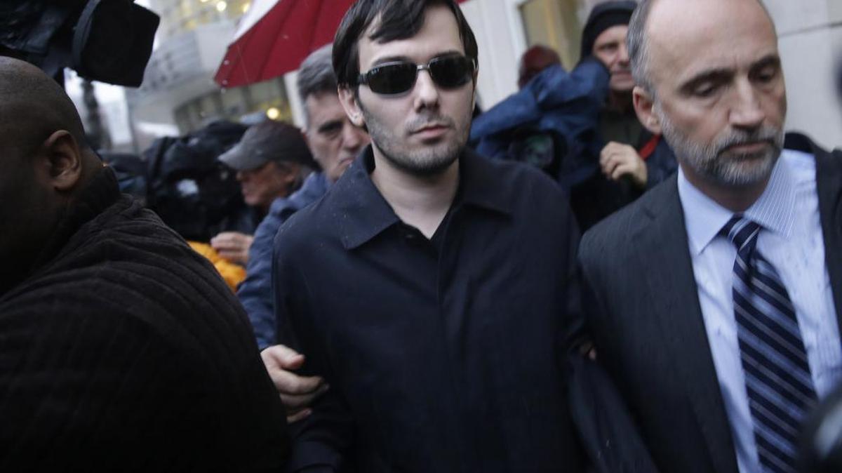 Martin Shkreli, center, leaves the courthouse after his arraignment in New York on Thursday. Shkreli, the former hedge fund manager vilified in nearly every corner of America for buying a pharmaceutical company and jacking up the price of a life-saving drug more than fiftyfold, was arrested Thursday on securities fraud charges unrelated to the furor, and resigned Friday from his position with the company.
