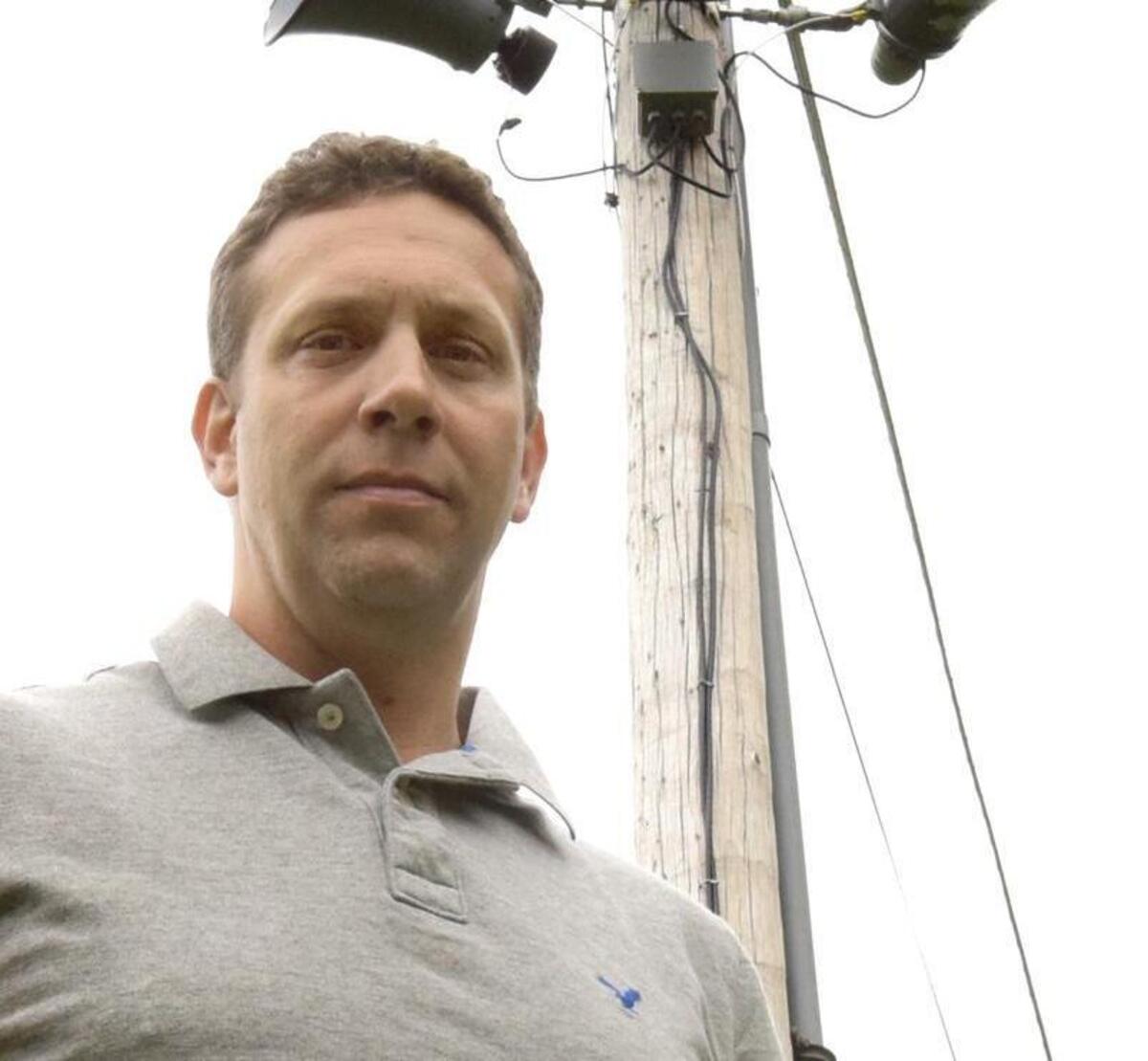 Naval officer Joshua Corney poses near the elevated speakers behind his Glen Rock, Pa., home on April 19, 2017. Corney broadcasts taps each night as a tribute to troops.