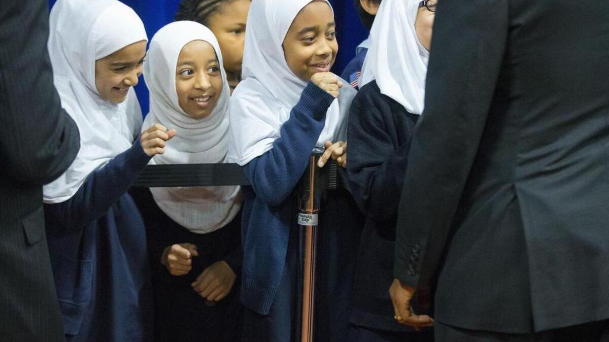 Young girls close their hands in anticipation of ‘fist-bumping’ President Barack Obama, right, who stop by to greet school children and other guests after speaking at the Islamic Society of Baltimore, Wednesday, Feb. 3, 2016, in Baltimore, Md.