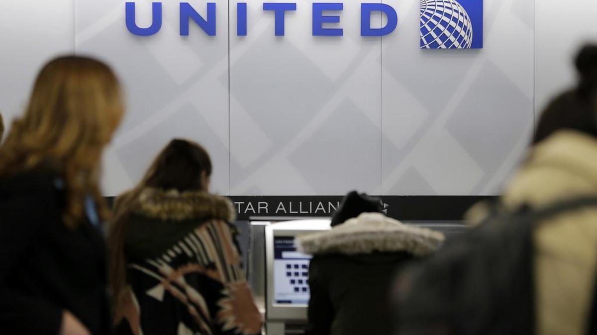 People stand in line at a United Airlines counter at LaGuardia Airport in New York in March. A dog died on a United Airlines plane after a flight attendant ordered its owner to put the animal in the plane's overhead bin. United said Tuesday, March 13, 2018, that it took full responsibility for the incident on the Monday night flight from Houston to New York.
