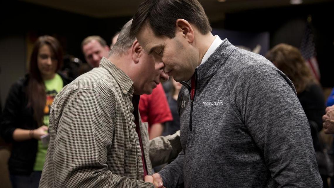 Republican presidential candidate Marco Rubio prays with Carl Hubbert after a rally Saturday in Council Bluffs, Iowa.