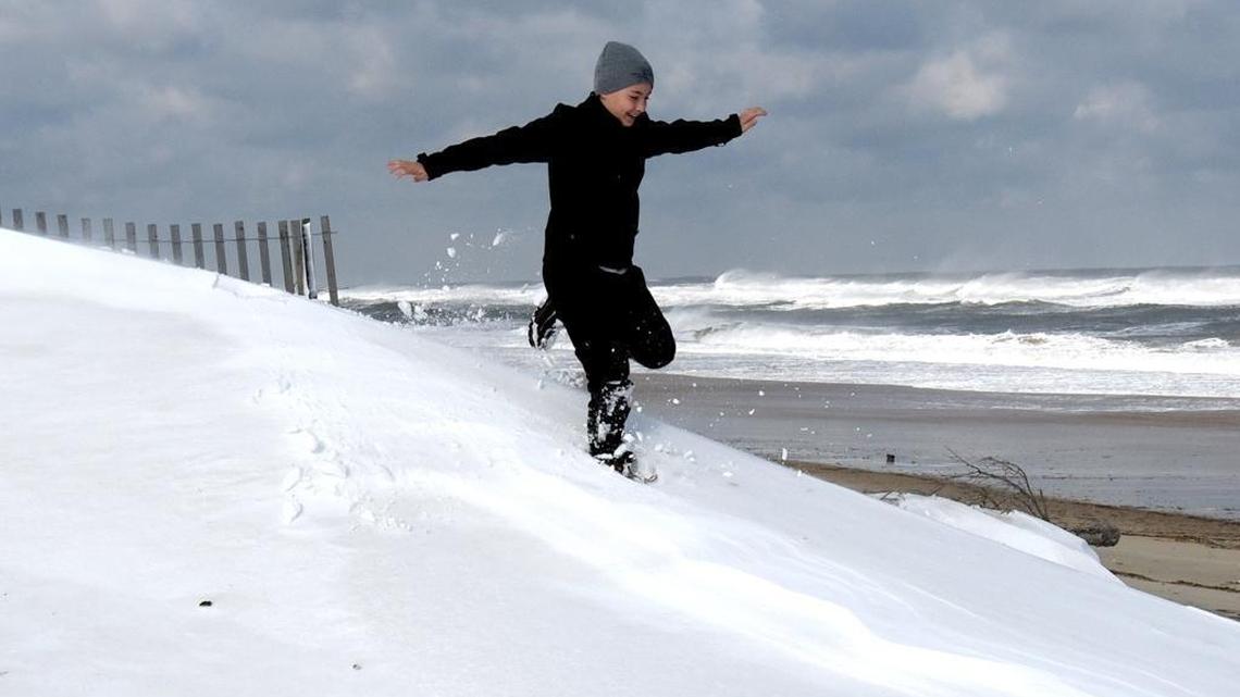 Nathan Stanley, 12 , of Abington, Va. runs through a beachfront snowdrift on Jan. 4, 2018 in Nags Head, North Carolina. Despite warming temperatures in much of the world, winters in the Southeast have grown colder in recent decades, an anamoly that scientists are calling a “hole” in global warming, or a “warming hole.”