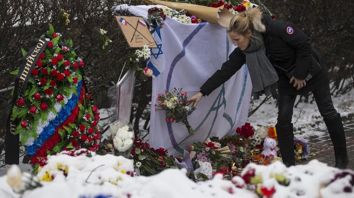 A woman places flowers in front of the French embassy in Moscow on Monday, Nov. 16, 2015. France and Russia have voiced new solidarity against the Islamic State, a partnership likely to draw the United States and Russia closer.