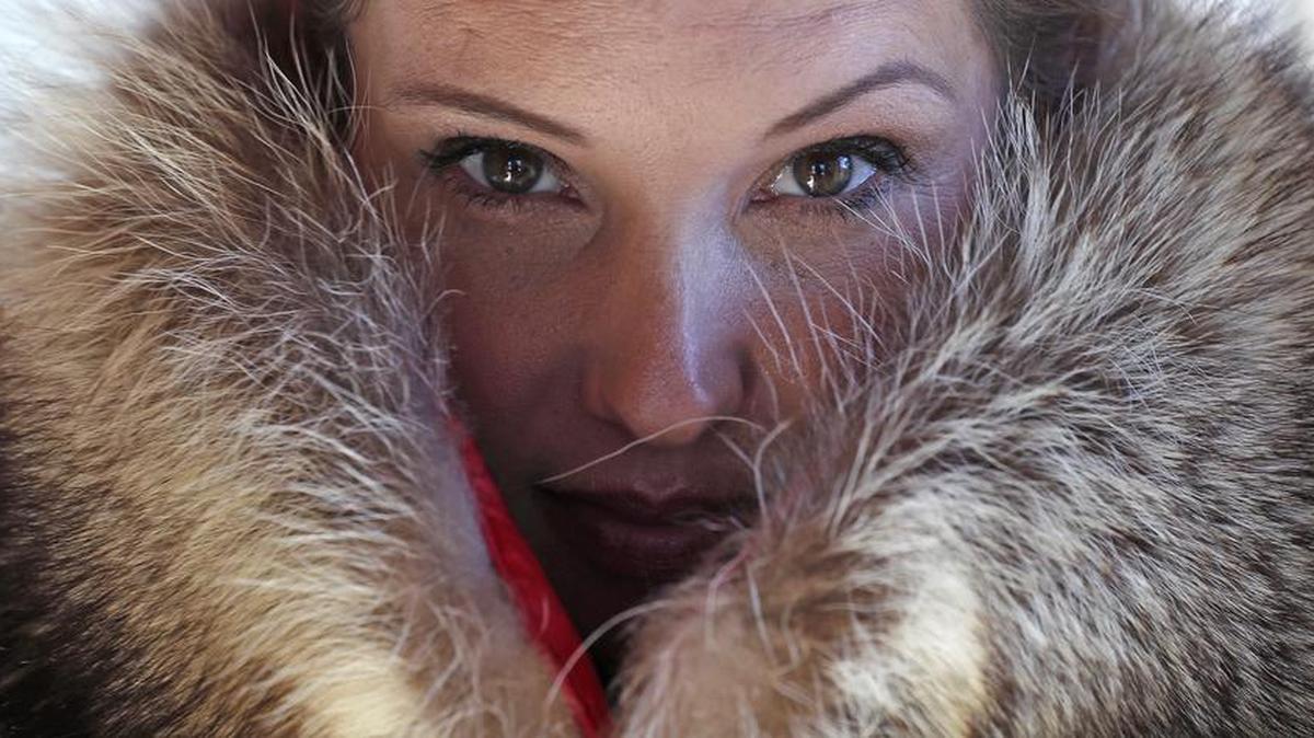 Pam Paquin poses with an "accidental fur" raccoon neck muff she created in central Massachusetts. Paquin's company, Petite Mort Furs, uses roadkill fur harvested from animal carcasses culled with the help of highway departments and animal control officers.