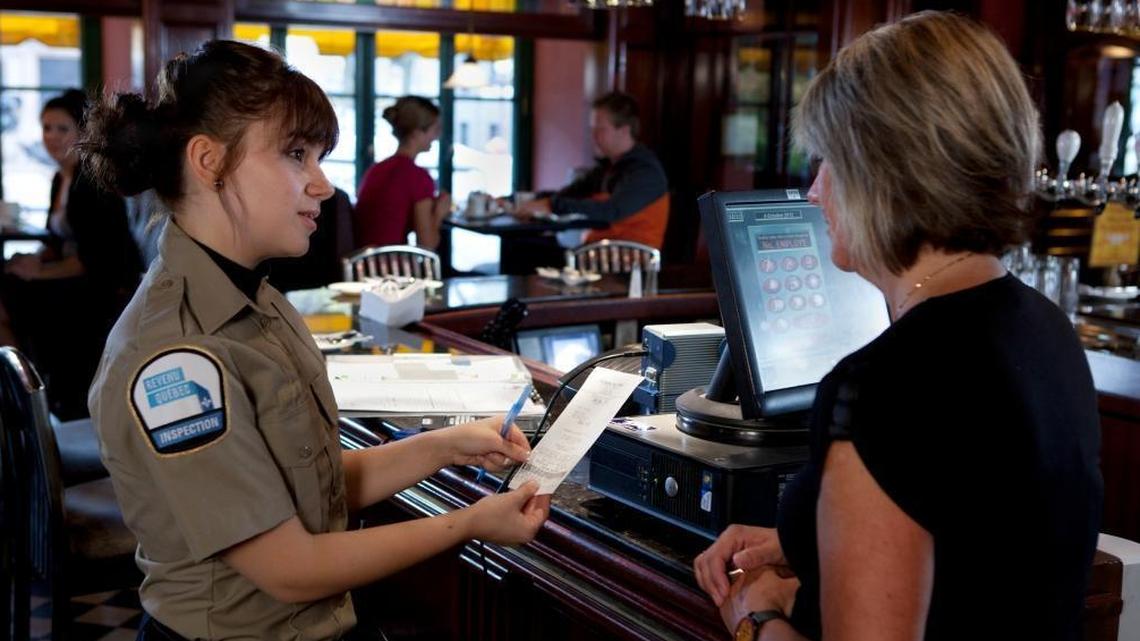 An inspector from Revenue Quebec examines a receipt at a restaurant in this undated photograph. Quebec’s tax authorities have gone further than those in the United States in combating sales tax fraud by restaurants and other businesses.