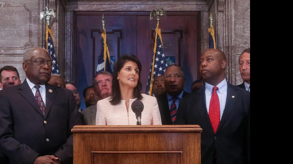 
South Carolina Gov. Nikki Haley speaks during a news conference in the South Carolina State House, Monday, June 22, 2015, in Columbia, S.C. Haley said that the Confederate flag should come down from the grounds of the state capitol, reversing her position on the divisive symbol amid growing calls for it to be removed. Also pictured are U.S. Congressman James Clyburn, left, and U.S. Sen. Tim Scott, right. 
