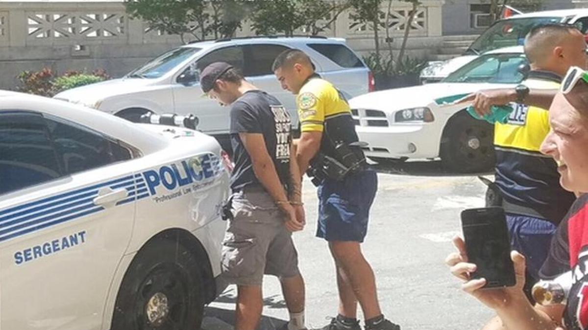 Jimmy John's delivery cyclist Mason Morales gets handcuffed by Miami police after he was hit by a car near the courthouse on Flagler Street in downtown Miami on Thursday, Aug. 31, 2017. Driving the unmarked police car was Kenia Fallat, a Miami Police spokesperson.