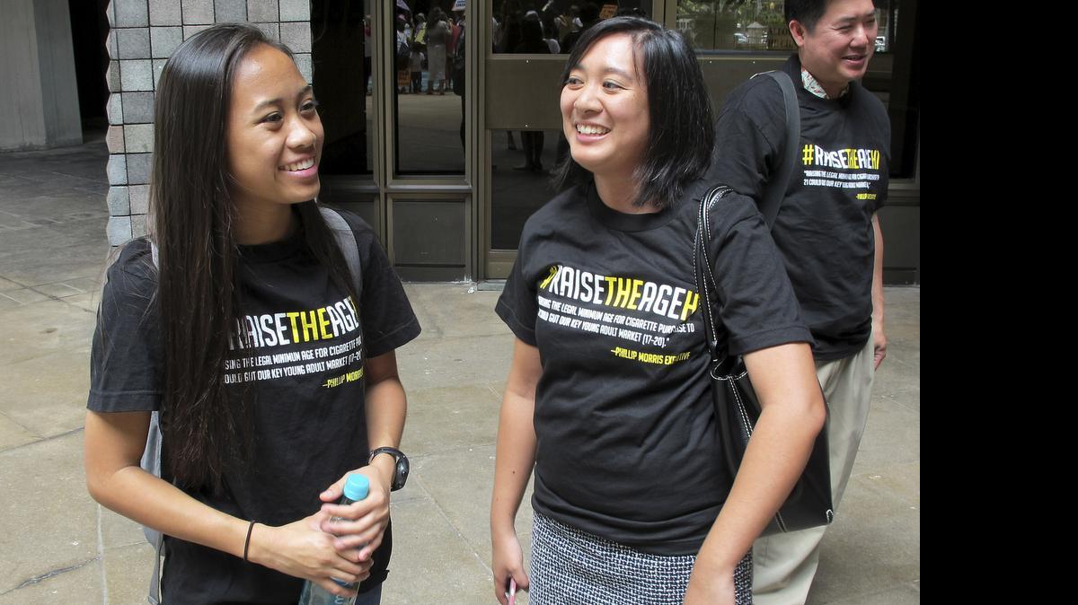 
Sabrina Olaes, left, a high school senior who supports raising the legal smoking age, reacts with Lyndsey Garcia, center, of the Coalition for a Tobacco-Free Hawaii and Cory Chun of the American Cancer Society Cancer Action Network outside the Hawaii Legislature after it passed a bill to raise the legal smoking age to 21 on Friday, April 24, 2015, in Honolulu. If Gov. David Ige signs the bill, Hawaii would be the first state in the nation to raise the legal smoking age to 21. 
