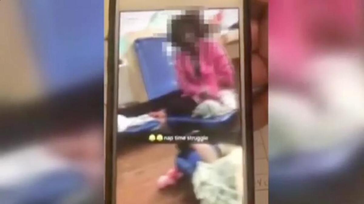 The video shows what appears to be a daycare worker smacking a young child laying on a cot.