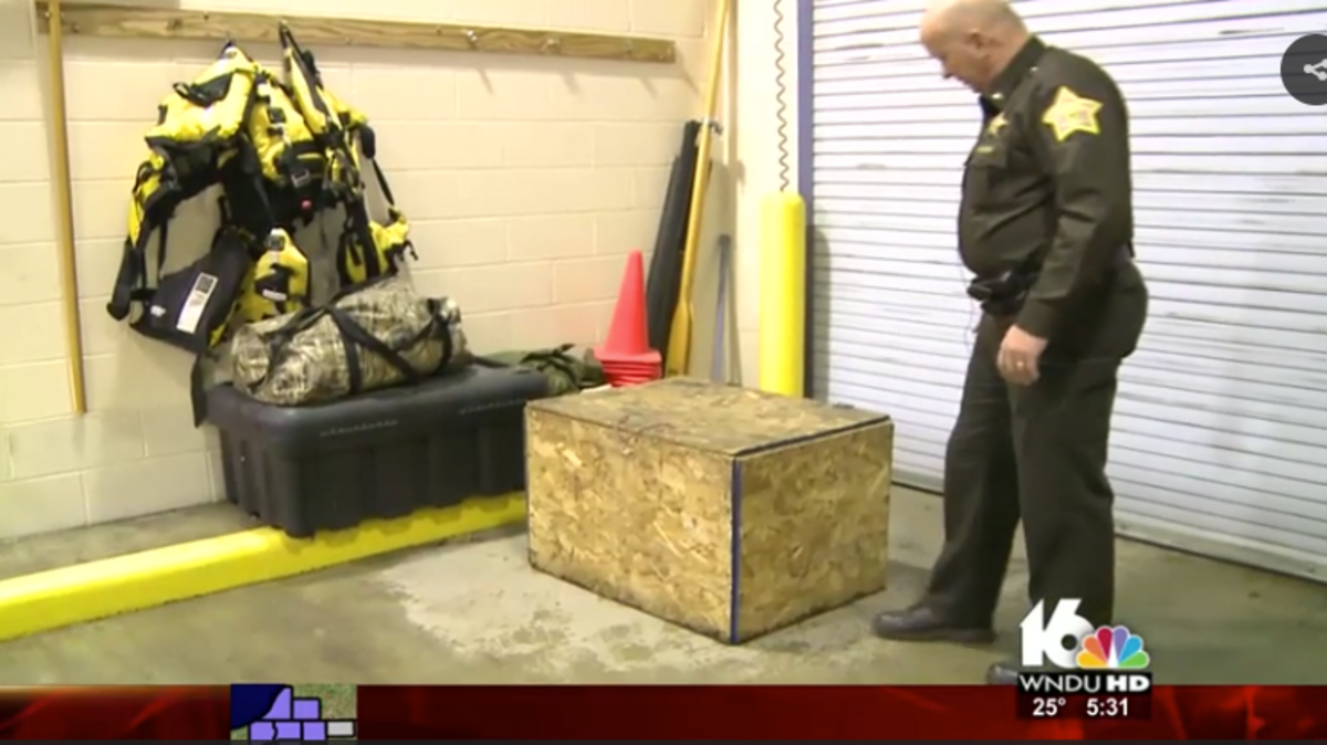Pulaski County (Indiana) Sheriff Jeffrey Richwine stands next to a plywood box. Police say a 3-year-old girl was found in the box, which was sometimes locked.