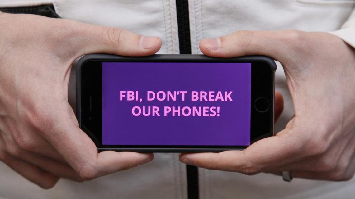 A man holds out his iPhone during a rally in support of data privacy outside the Apple store Tuesday, Feb. 23, 2016, in San Francisco. Protesters assembled in more than 30 cities to lash out at the FBI for obtaining a court order that requires Apple to make it easier to unlock an encrypted iPhone used by a gunman in December’s mass murders in California.