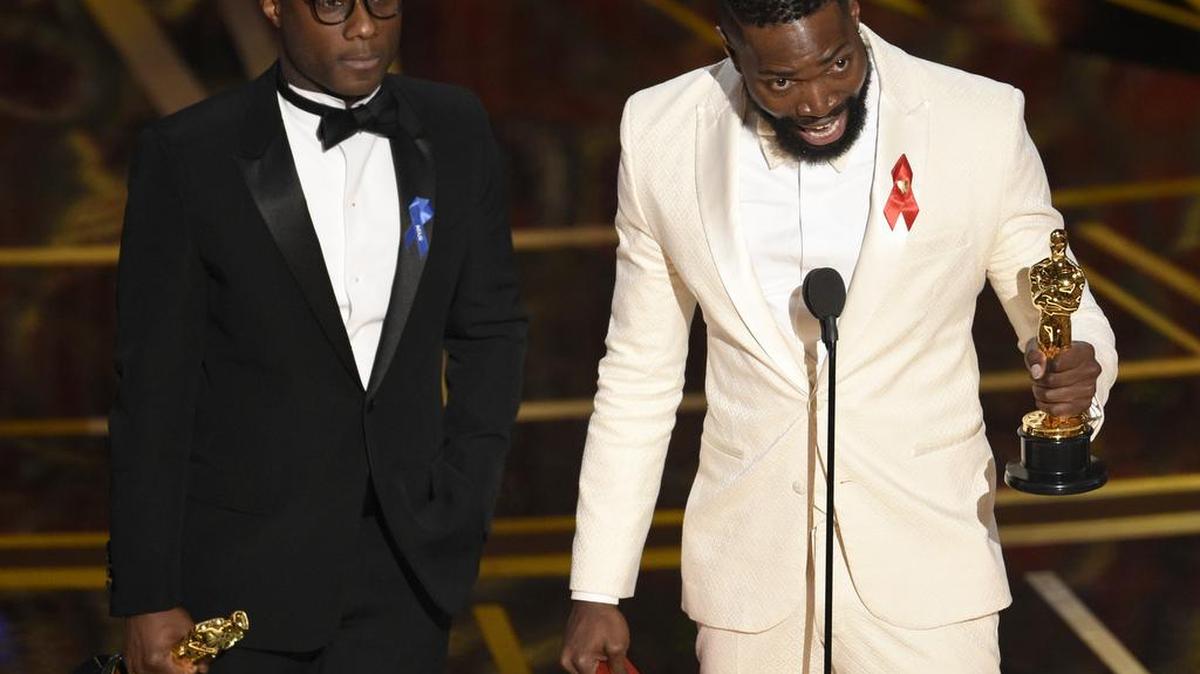 Barry Jenkins, left, and Tarell Alvin McCraney accept the award for best adapted screenplay for "Moonlight" at the Oscars on Sunday, Feb. 26, 2017, at the Dolby Theatre in Los Angeles.