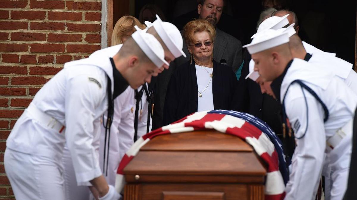 Ronnie Kissinger, center, stands near the casket holding the remains of her relative Albert Eugene Hayden following a funeral mass for Hayden, who died in the 1941 aattack on Pearl Harbor, at St. Joseph Catholic Church on Wednesday in Morganza, Md.. Hayden's body was brought to Maryland after it was identified through testing.