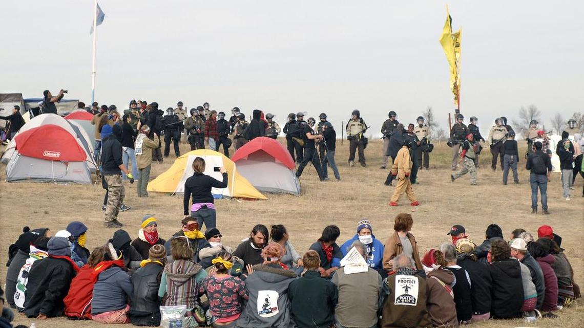 Dakota Access Pipeline protesters sit in a prayer circle at the Front Line Camp on Oct. 27, 2016, as a line of law enforcement officers make their way across the camp to remove the protesters and relocate to the overflow camp a few miles to the south on Highway 1806 in Morton County, N.D. Members of more than 200 tribes from across North America have come to the Standing Rock Sioux Tribe's encampment at the confluence of the Missouri and Cannonball rivers since August, the tribe says. Estimates at the protest site have varied from a few hundred to several thousand depending on the day _ enough for tribal officials to call it one of the largest gatherings of Native Americans in a century or more.