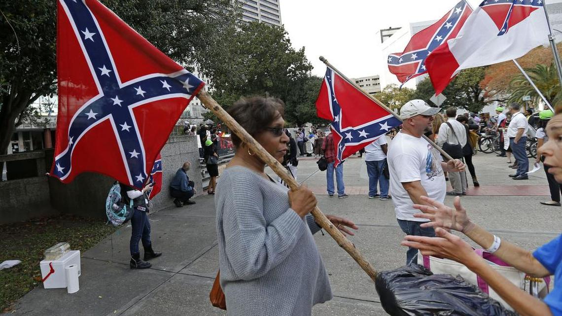 Arlene Barnum, of Oklahoma, with a group calling themselves Confederate Veterans Lives Matter, holds a Confederate flag in front of City Hall in New Orleans on Thursday. City Hall became the scene of competing opinions over the removal of prominent Confederate monuments along some of New Orleans' busiest thoroughfares. The City Council set aside time to let the public voice feelings over a proposal to remove four monuments linked to Confederate history.