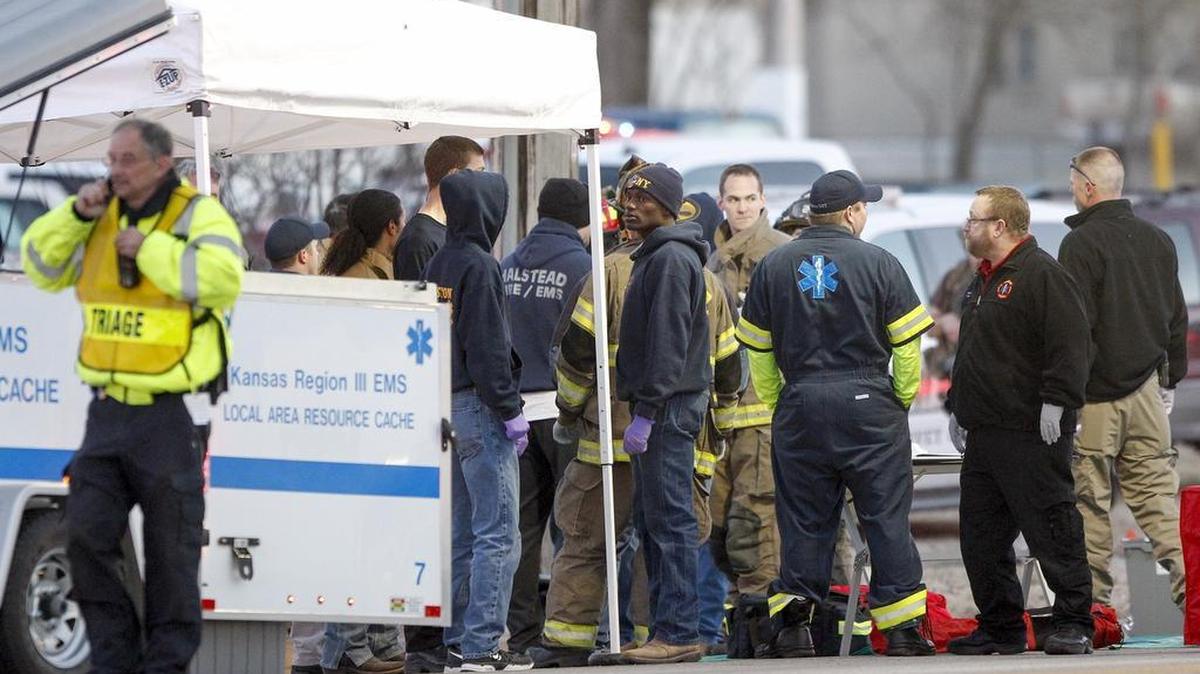 EMS workers gather a staging area by Excel Industries, where a gunman killed three people Thursday in Hesston, Kan.