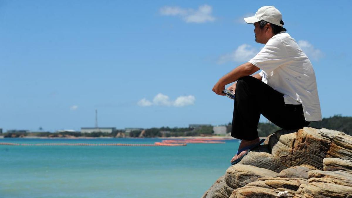 Takuma Higashionna looks across the blue waters of Oura Bay towards Camp Schwab in Okinawa on July 23, 2015. Higashionna, who has memories of swimming with the dugong, is against plans to fill in a large portion of the bay to build airstrips for the U.S. military. The environmentally sensitive area is home to many species of coral, fish, and the Okinawan dugong, a mammal protected by the Japanese government.