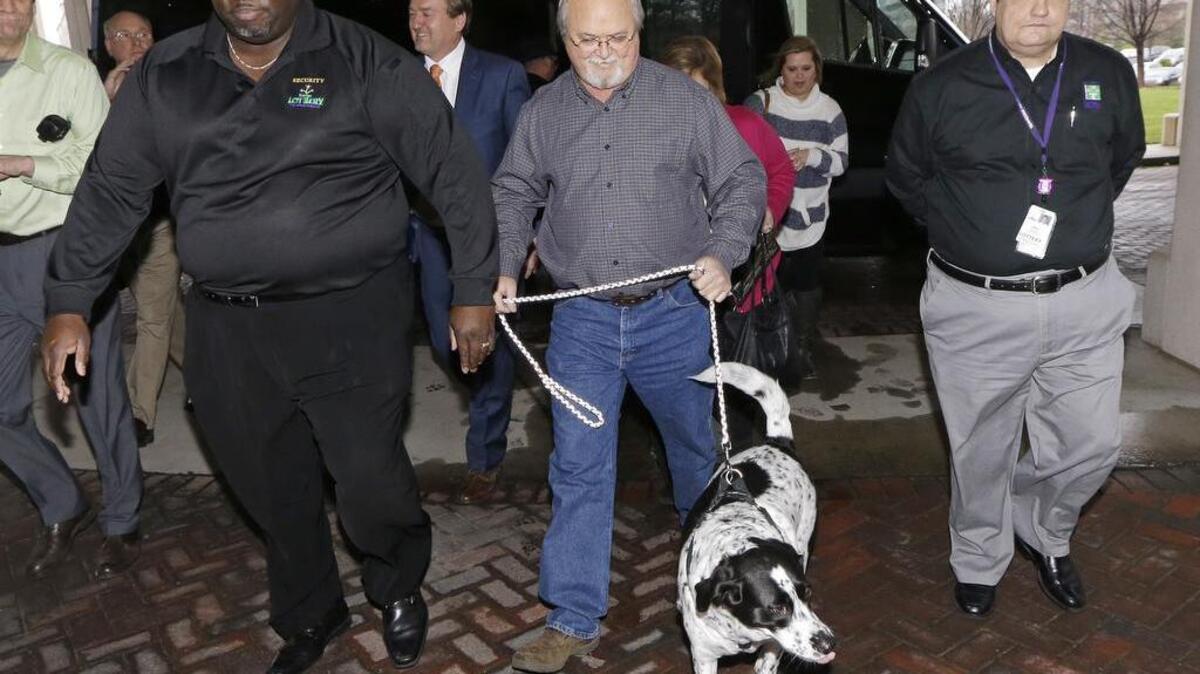 John Robinson, center, of Munford, Tenn., arrives with his dog at the Tennessee Lottery headquarters, Friday, Jan. 15, 2016, in Nashville, Tenn. Robinson had one of the winning tickets in the record $1.6 billion jackpot drawing that took place Wednesday.