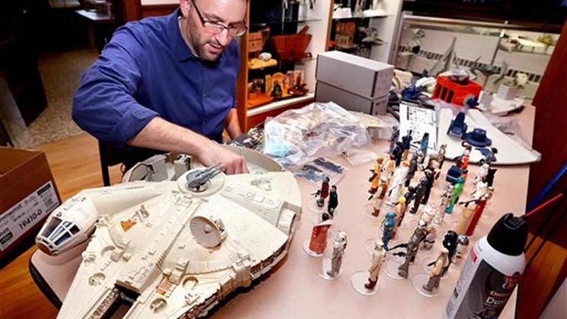 In this photo taken Wednesday, Nov. 18, 2015, Jarrod Roll, director of the Monroe County Local History Room in Sparta, Wis. prepares his vintage Millennium Falcon toy for the upcoming exhibit "Star Wars, The Nostalgia Awakens." The exhibit of action figures, toy vehicles and play sets made from 1978 to 1985 opened Monday, Nov. 23.