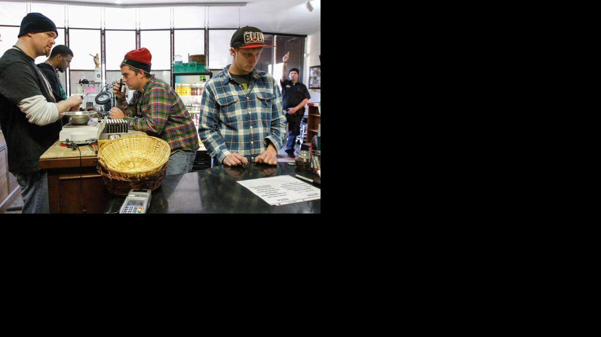
Budtender Derek Richards, left, helps Carson Jones of Lincoln, Neb., while Jones’ brother Jack, also of Lincoln, finishes his order. When Colorado and Washington won permission from the U.S. Justice Department to begin selling marijuana in retail stores, the states promised to keep the pot inside their borders and away from children. It’s a big challenge. 
