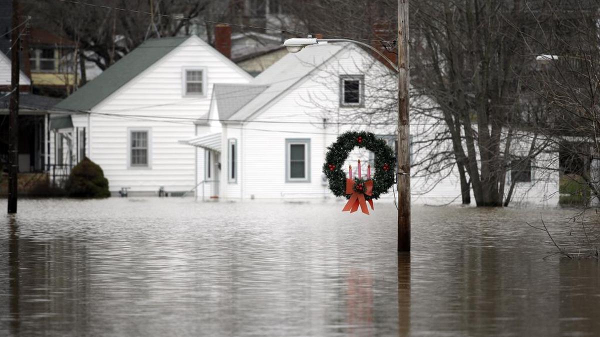 A holiday wreath hangs from a light post surrounded by floodwater from the Bourbeuse River, Tuesday, Dec. 29, 2015, in Union, Mo. Flooding across Missouri has forced the closure of hundreds of roads and threatened homes.