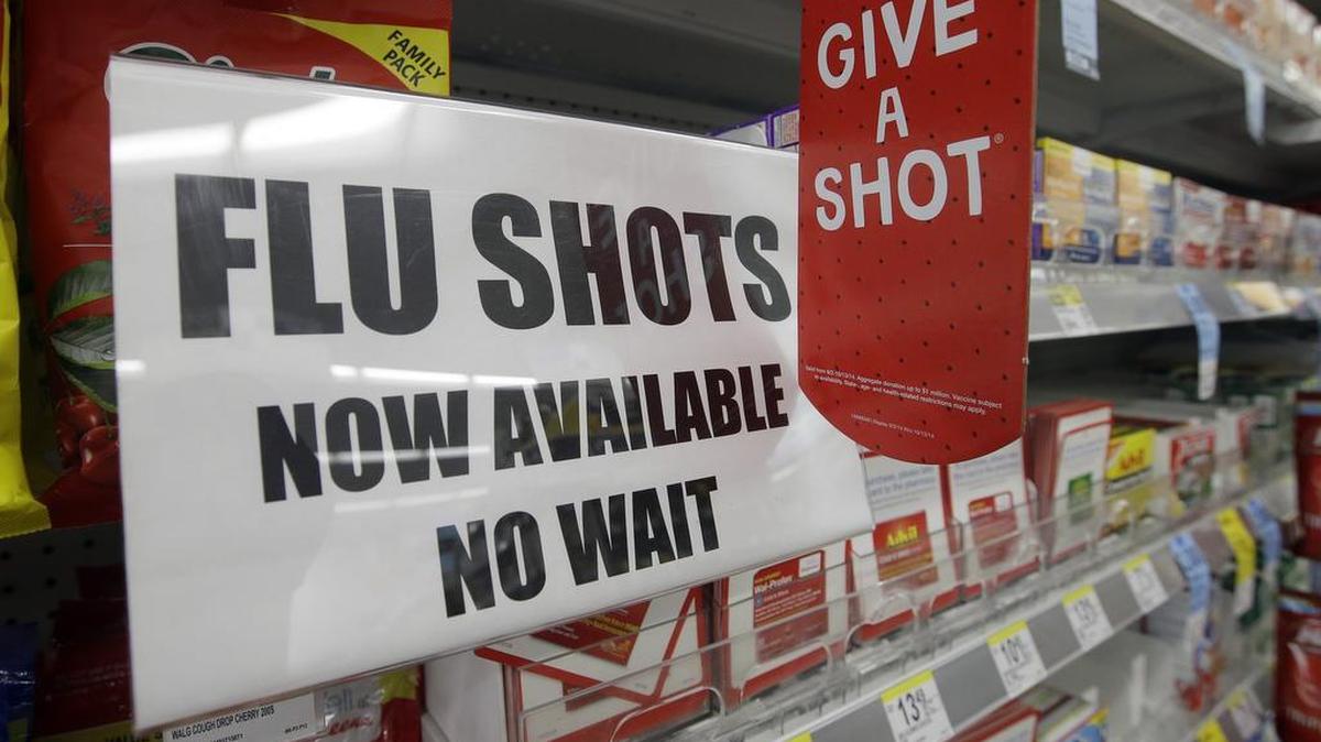 This Sept. 16, 2014 file photo, a sign telling customers that they can get a flu shot in a Walgreen store is seen in Indianapolis.