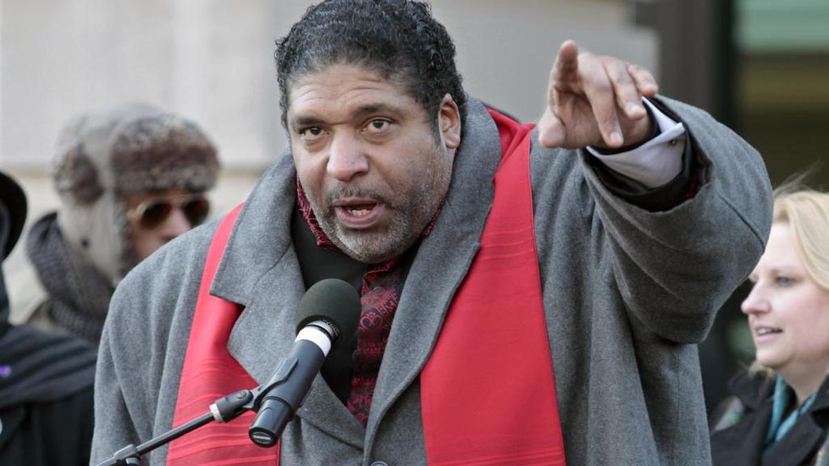Rev. William Barber urges HKonJ march protesters to both donate to the cause and get in their march groups at the end of the rally portion in front of Memorial Auditorium in downtown Raleigh, NC Saturday morning, February 13, 2016. Rev. Barber was one of the many speakers for the 10th annual Historic Thousands on Jones Street protest march. An estimated five thousand marchers braving the below freezing temps and wind chill.