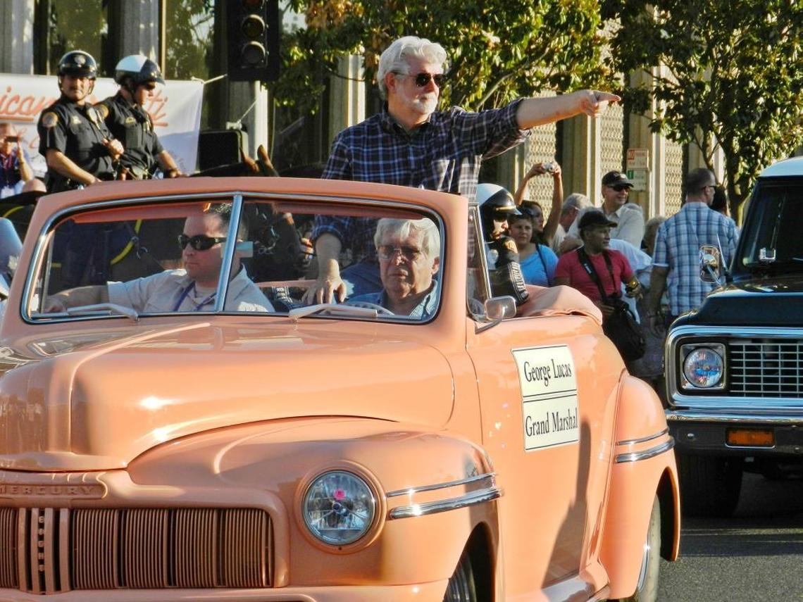 Modesto native son and iconic filmmaker George Lucas points to the crowd during the 2013 American Graffiti Classic Car Parade in Modesto, Calif., on June 7, 2013.