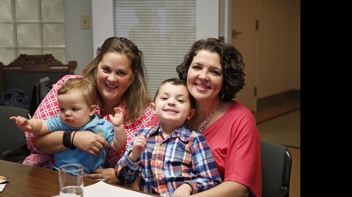 
Pam Yorksmith, left, and her spouse, Nicole Yorksmith, along with their children, Grayden, 4, and Orion, are photographed in the office of their attorney, Gerhardstein & Branch Co. LPA, Friday, April 3, 2015 in Cincinnati. A middle-of-the night trip to the emergency room, with her 9-month-old son coughing and laboring to breathe, gave Pam Yorksmith her latest reminder of why she took up the fight for same-sex marriage. Before baby Orion could be treated for croup, the hospital had to call his birth mother, Yorksmith’s wife, Nicole, "to get permission to treat my child," Yorksmith said. The are among the 19 men and 12 women whose same-sex marriage cases from those two states, plus Michigan and Tennessee, will be argued at the Supreme Court on April 28. 

