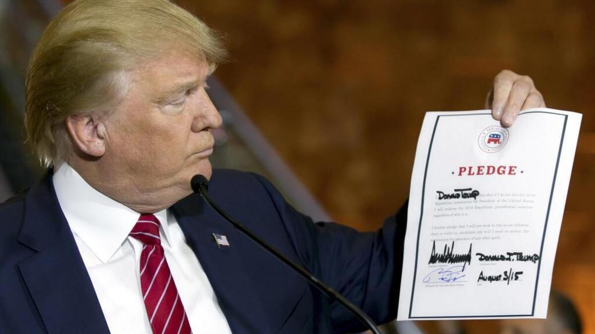 
Republican presidential candidate Donald Trump looks at a signed pledge during a news conference in Trump Tower in New York on Thursday, Sept. 3, 2015, at which he said he would not stage a third-party run. It was a chaotic summer for the unruly pack of 17 major Republican presidential contenders. Trump rocketed into front-runner status and has shown remarkable staying power. 
