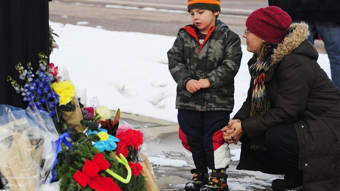 Korbyn Fair and his mother, Nasya, say a prayer Sunday in Colorado Springs, Colo., at the memorial for the victims of Friday's deadly shooting at a Planned Parenthood clinic.