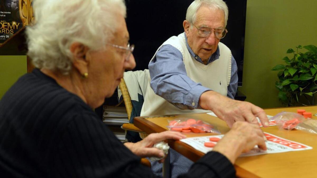 Harry Baron and his wife, Claire, play Bingo at Arbor Terrace, an assisted living community in Marietta, Ga., Nov. 20, 2013. This year’s median annual price of a private nursing home room is $92,378 and a “semi-private” shared room is $82,125. In-home health aide services cost $46,332 and adult day care is $17,680.